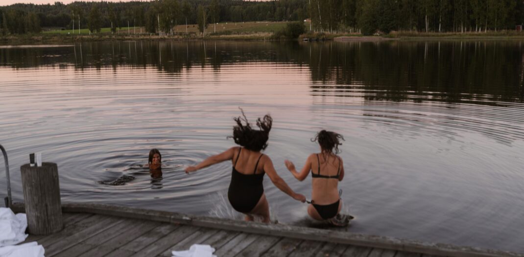 Kvinnor hoppar från bryggan i sjön Fryken